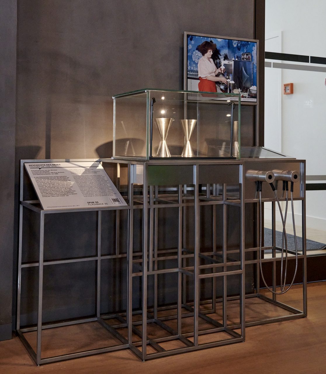 Modern exhibition with glass cases and information signs, surrounded by minimalist displays.