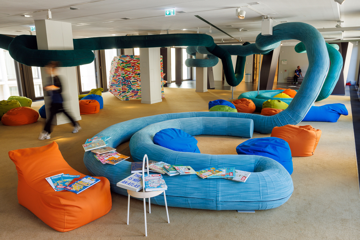 Colorful seating and books in a modern, inviting space with curved design.