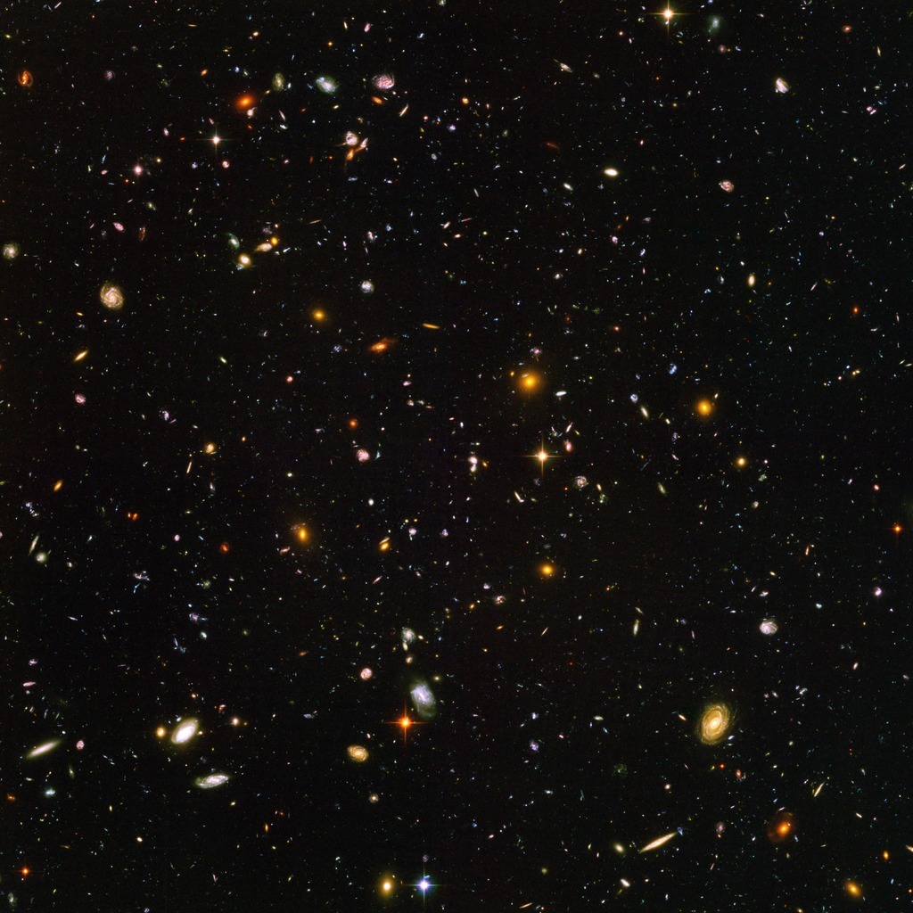 A vast, starry universe with numerous galaxies against a dark background.